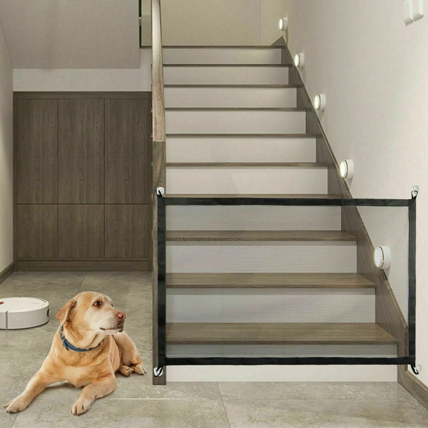 Black mesh pet barrier across the bottom of a staircase with a dog lying in front of it