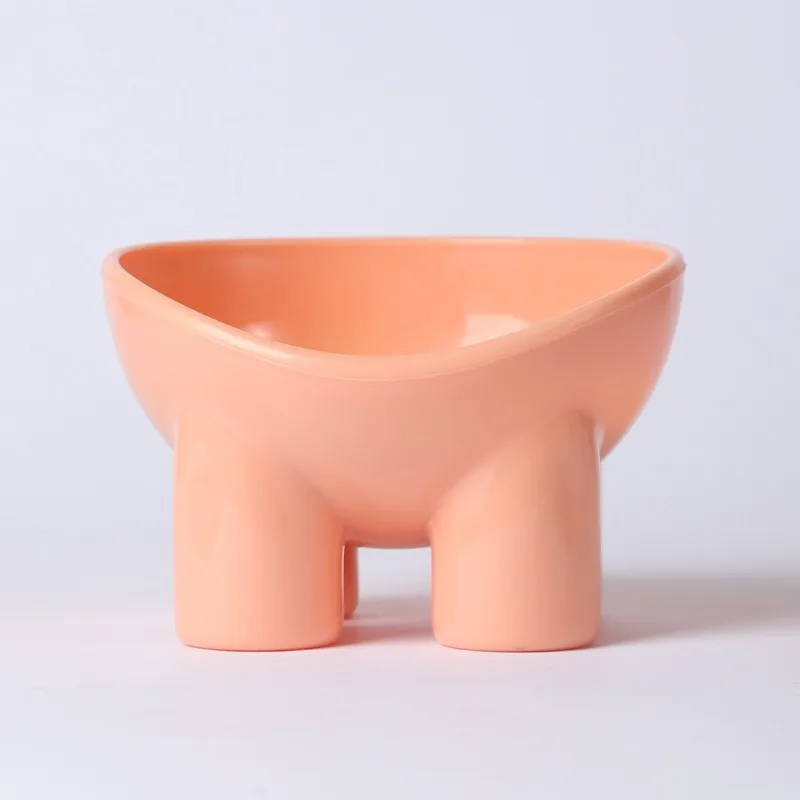 Pink raised plastic bowl on four short legs, with a tilted rim