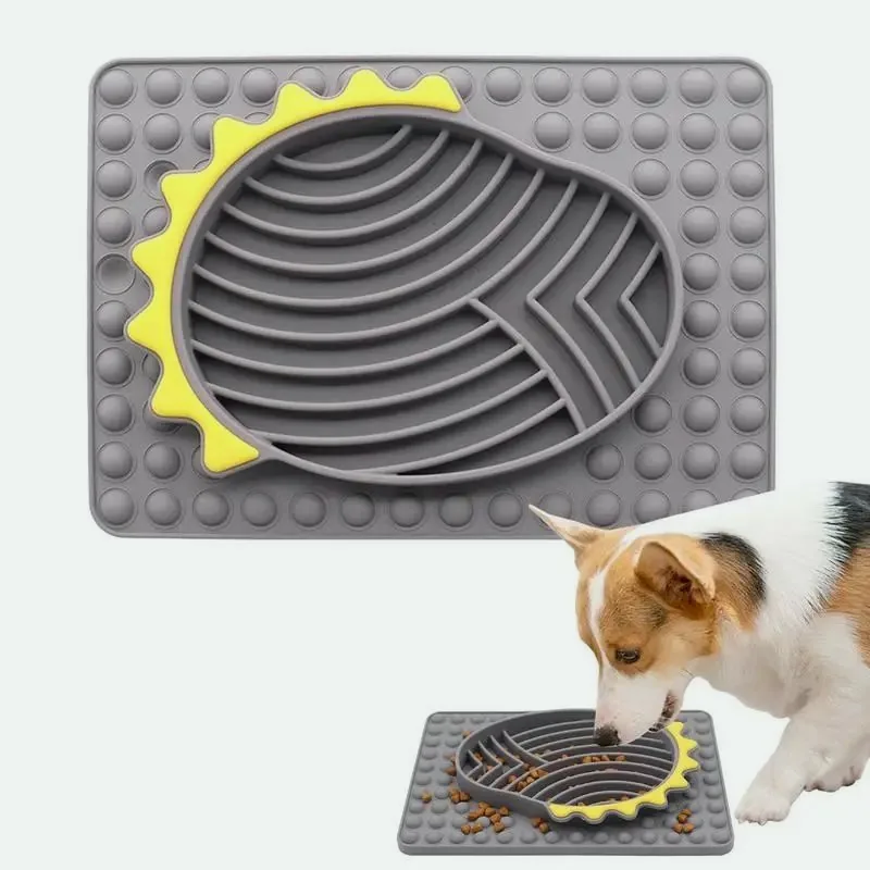 Grey silicone slow feeder with curved ridges and a yellow edge, with a corgi eating from one